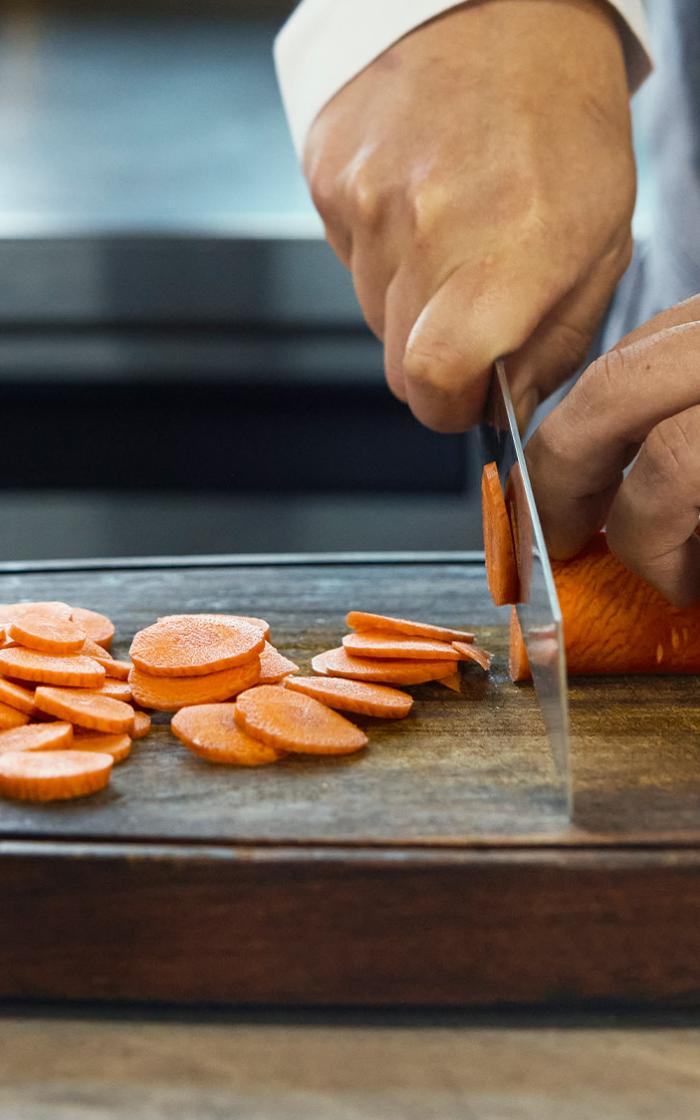 Close up of Krug Ambassade Chef Vicky Cheng cutting a carrot