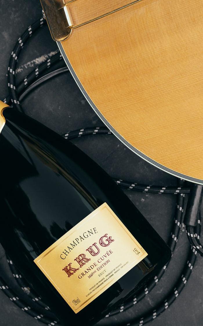 A bottle of Krug next to an electric guitar